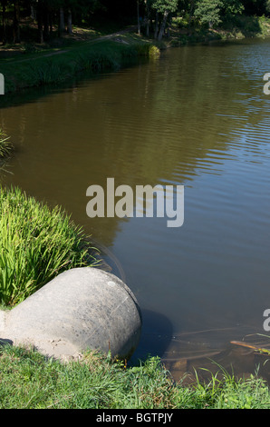 Fognature andando fuori sulle rive di un fiume. Foto Stock