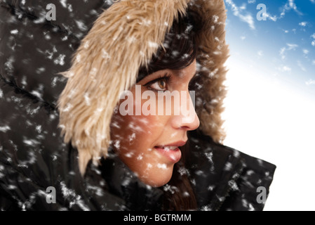 Donna che indossa parka nero con cappa pelliccia nella neve Foto Stock