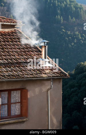 Fumo proveniente dal camino in una casa di San Marziale, borgo medievale nella valle Rieutord Gard, il sud della Francia Foto Stock