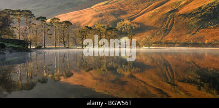 Vista panoramica del lago Buttermere in autunno con la Lakeland Fells riflessa sulla calma piatta superficie, Lake District, Cumbria Foto Stock