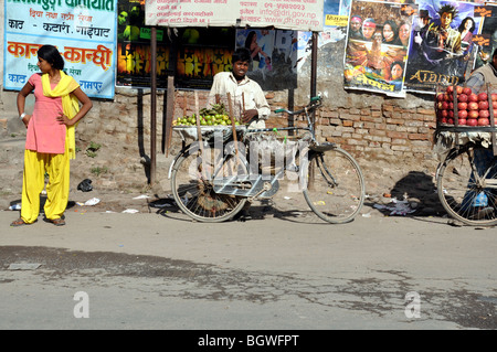 Giovani nepalesi uomo per la vendita di frutta dalla sua bicicletta sulla strada a Kathmandu Foto Stock