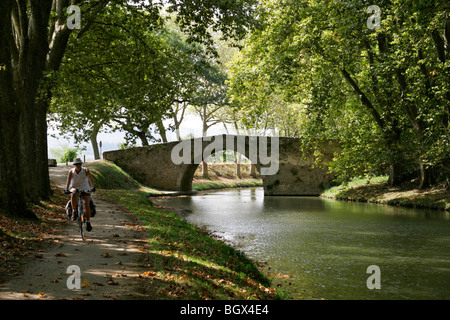 Donna bicicletta piccolo ponte Canal du Midi Trebes da Carcassonne Aude Francia Foto Stock