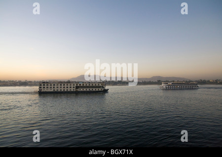 Hotel moderno di lusso barche crociera passando sul fiume Nilo al tramonto, Luxor, Egitto, Nord Africa Foto Stock