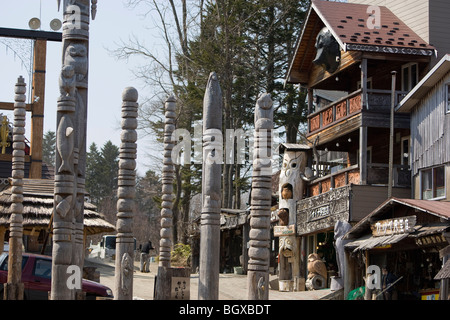 Legno intagliato in poli di attrazione turistica del villaggio Ainu in Akanko Onsen cittadina sulle rive del Lago Akan, Hokkaido. Foto Stock