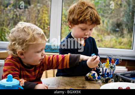 Due fratelli giocando con Lego edificio giocattolo. Foto Stock