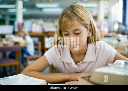 Ragazza Preteen studiare in biblioteca Foto Stock