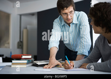 Insegnante spiegando l'assegnazione a studente Foto Stock