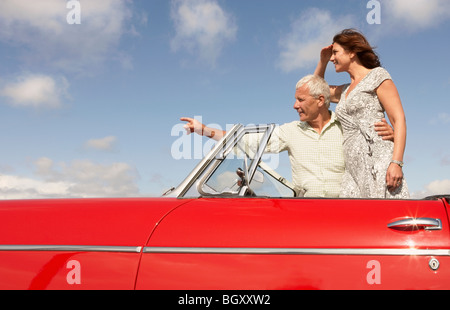 Coppia senior in auto sportiva, puntamento Foto Stock