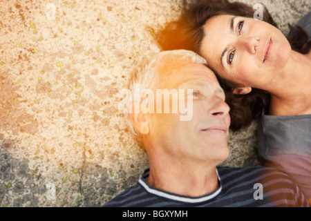 Coppia di mezza età su rocce con flare Foto Stock