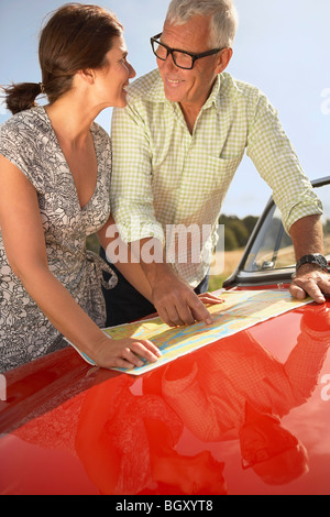 Coppia senior con auto e mappa Foto Stock