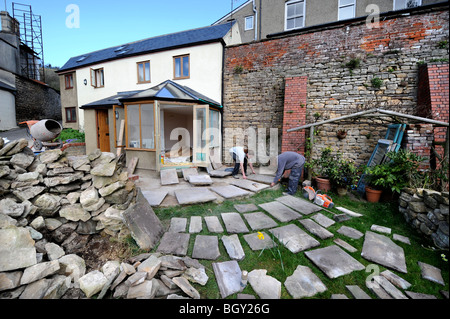 Costruttori di lay out di pietra naturale in lastre nella pianificazione di un patio, GLOUCESTERSHIRE REGNO UNITO Foto Stock