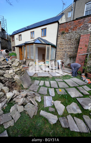 Costruttori di lay out di pietra naturale in lastre nella pianificazione di un patio, GLOUCESTERSHIRE REGNO UNITO Foto Stock