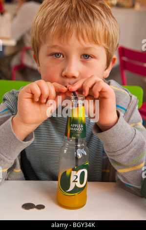 Un bambino di sei anni ragazzo beve un J2o bere succo di frutta in Inghilterra , Inghilterra , Regno Unito Foto Stock