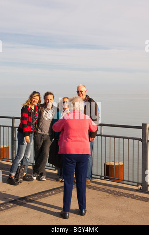 Grannny prende una foto di famiglia sul molo di Southwold , Suffolk , Inghilterra , Inghilterra , Regno Unito Foto Stock