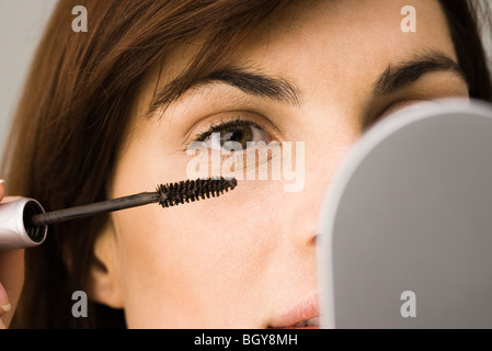 Giovane donna mettere il mascara Foto Stock