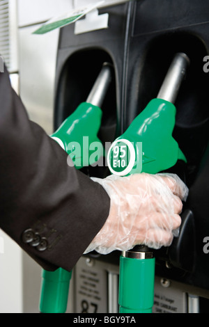 A pompa del gas con la mano guantata Rimozione ugello Foto Stock