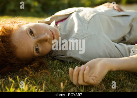 Giovane donna sdraiata sulla schiena in erba Foto Stock