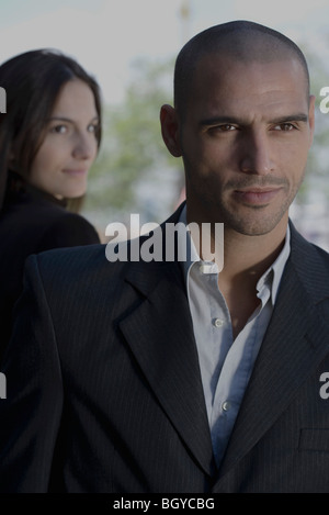 Donna che guarda oltre lo spallamento a ben vestito uomo in primo piano Foto Stock