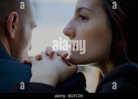 Donna mento di appoggio sulle mani giunte poste all'uomo della spalla Foto Stock