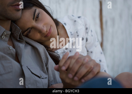 Coppia giovane Holding Hands, donna appoggiato la testa sull'uomo spalla Foto Stock