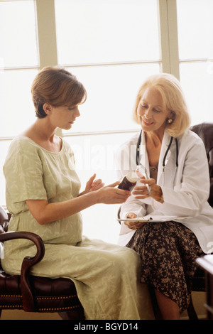 Ostetrico a parlare con una donna in stato di gravidanza Foto Stock