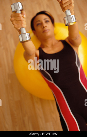 Donna che esercitano con pesi Foto Stock