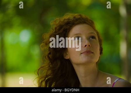 Giovane donna guardando in alto, ritratto Foto Stock