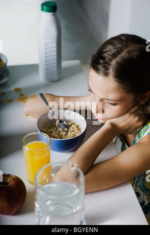 Ragazza broncio al tavolo per la colazione Foto Stock