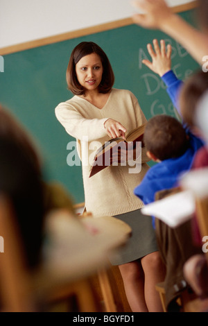 Insegnante chiede a studente in aula Foto Stock