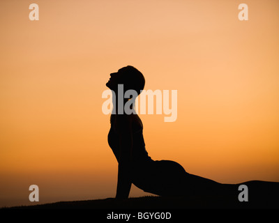 Silhouette di donna fare yoga Foto Stock