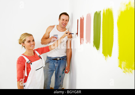 Donna pittura i campioni di colore sulla parete Foto Stock