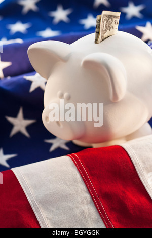 Piggybank sulla parte superiore della bandiera americana Foto Stock