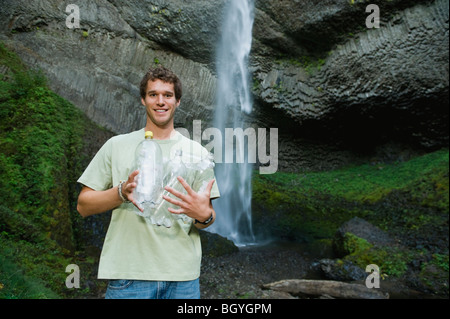 Uomo con vuoti di bottiglie di acqua Foto Stock