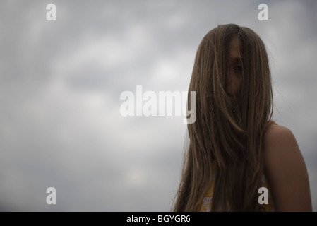 Femmina con la faccia oscurata da capelli lunghi Foto Stock