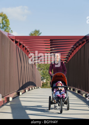 La donna a spingere un passeggino Foto Stock