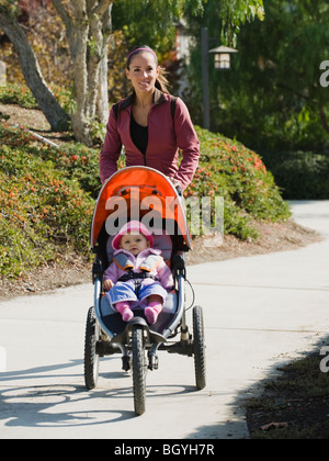 Donna fare jogging con il passeggino Foto Stock