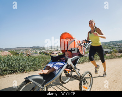 Donna fare jogging con il passeggino Foto Stock