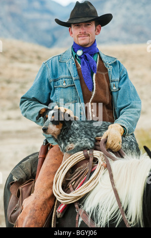 Cowboy e cane a cavallo Foto Stock