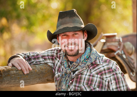 Cowboy appoggiato su di recinzione Foto Stock