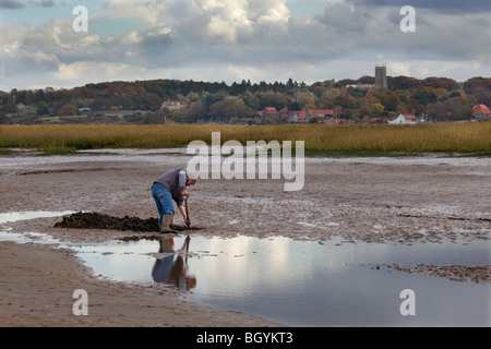 Esca digger a bassa marea nel porto di Blakeney UK Ottobre verso la Chiesa Blakeney Foto Stock
