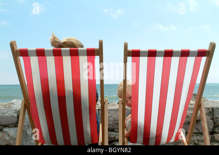 I turisti nel Devon seduti su sedie a sdraio Foto Stock