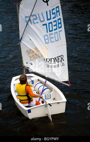 Giovane marinaio in bianco Optimist imbarcazione a vela vela a san Giuseppe, Michigan, Stati Uniti d'America Foto Stock