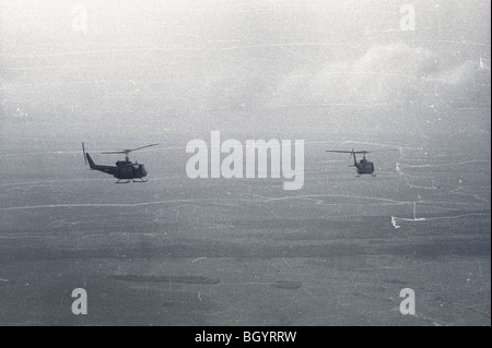 Due elicotteri del sistema AHC 121 fuori di Soc Trang, Vietnam, volare in formazione su una missione durante la Guerra del Vietnam. Foto Stock