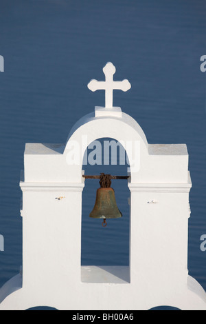 St Gerasimos Chiesa cristiana Campanile e croce a Firostefani sull'isola di Santorini, sullo sfondo blu del Mar Mediterraneo Foto Stock