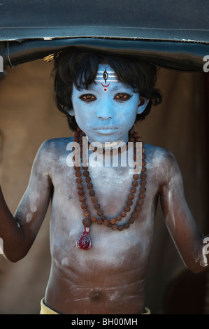 Ragazzo indiano, faccia dipinta come il dio indù Shiva in piedi in un rickshaw. Andhra Pradesh, India Foto Stock