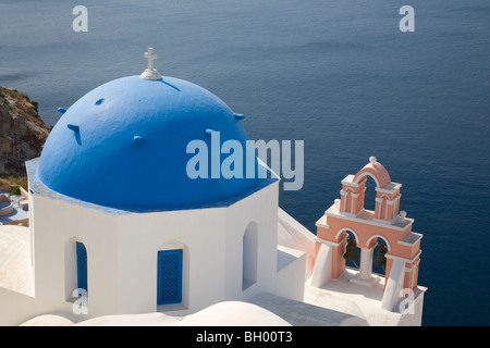 La chiesa a cupola blu e il campanile in un villaggio che si affaccia sulla laguna di Santorini, Oia, Grecia Foto Stock