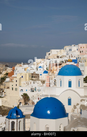 Chiese bianche con cupola blu nella pittoresca cittadina di Oia, sulla cima di una scogliera, sull'isola di Santorini Foto Stock