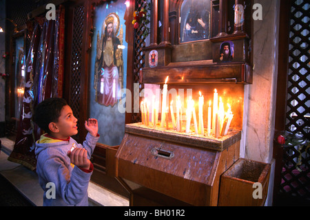 Un cristiano copto boy in preghiera nella chiesa della Santa Vergine in Il Cairo Egitto Foto Stock