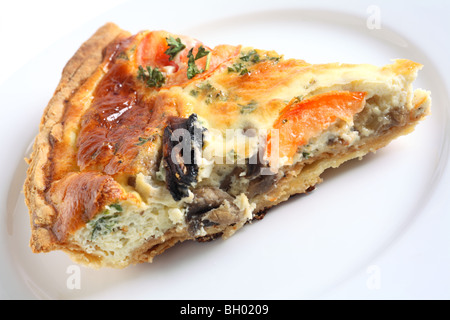 Una fetta di fungo quiche su una piastra bianca. Foto Stock