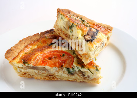 Due fette di un fungo vegetariani quiche su una piastra bianca Foto Stock